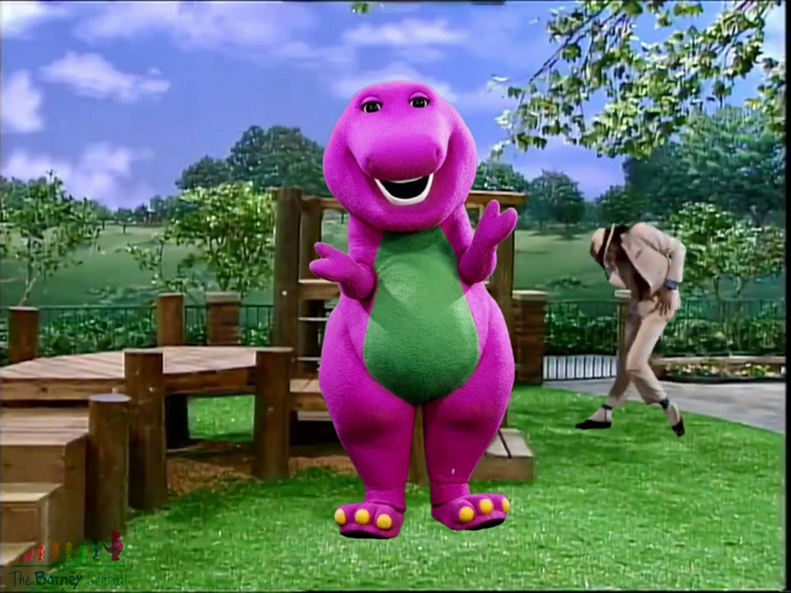 The bright pink-purple Barney dinosaur with a green belly in the garden scene from thebarneycentral’s fan edit.