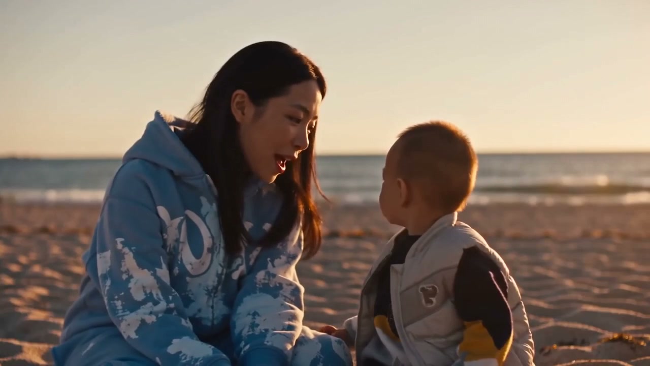 A woman and child together on the beach in the generated Raindance sunset scene.